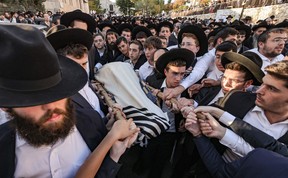 Ultra-Orthodox Jewish mourners carry the body of Aryeh Schupak, 15, an Israeli-Canadian killed in an attack on a bus stop in Jerusalem, during his funeral on Nov. 23, 2022.