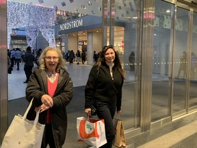 Shoppers Linda Aylward (left) and Brynna Aylward leave the Eaton Centre after looking for Black Friday deals on Nov. 25, 2022.