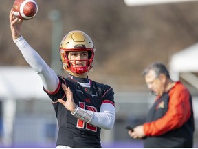 Arnaud Desjardins the starting quarterback for the Laval Rouge et Or keeps his arm warm as head coach Glen Constantin looks on in the background.
Laval and the Saskatchewan Huskies meet in London at Alumni Field Saturday for the Vanier Cup. 
Photograph taken on Thursday November 24, 2022.