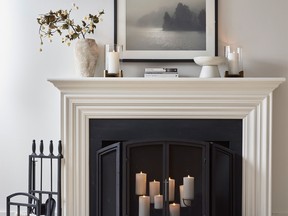 Filling an unused fireplace with candles is an easy way to emulate the warm of the flame. Fireplace Candleholder, $183, Pottery Barn.