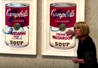A climate activist glues herself to Andy Warhol artwork in Canberra in this screengrab from video.