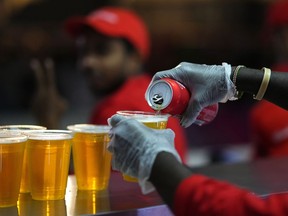 FILE - Staff member pours a beer at a fan zone ahead of the FIFA World Cup, in Doha, Qatar Saturday, Nov. 19, 2022. The last-minute decision to ban the sale of beer at World Cup stadiums in Qatar is the latest example of some the tensions that have played out ahead of the tournament. Qatari officials have for long said they were eager to welcome everybody but that visitors should also respect their culture and traditions.