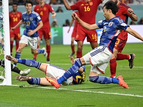 Kaoru Mitoma of Japan keeps the ball in play to set up Japan's second goal against Spain.