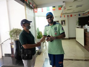 Neymar lookalike Eigon Oliver (right) shakes hands with a fan.