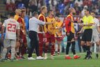 Serbia head coach Dragan Stojkovic intervenes as his players encroach onto the pitch as referee Fernando Andres Rapallini.