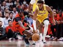 Chris Boucher of the Toronto Raptors (left) reaches for a loose ball alongside Troy Brown Jr. of the Los Angeles Lakers during the first half of their NBA game at Scotiabank Arena on Dec. 7, 2022 in Toronto.