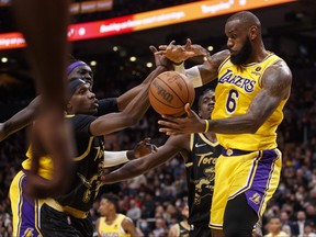 LeBron James of the Los Angeles Lakers grabs a rebound from Chris Boucher of the Toronto Raptors during the second half of their NBA game at Scotiabank Arena on March 18, 2022 in Toronto, Canada.