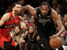 Kevin Durant of the Nets stiff-arms Fred VanVleet as he drives to the Raptors hoop last night at the Barclays Center. It was that kind of night for the Raptors.