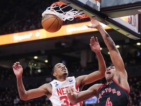 Scottie Barnes #4 of the Toronto Raptors goes up for a slam dunk against Nic Claxton #33 of the Brooklyn Nets during the second half of their basketball game at the Scotiabank Arena.