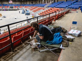 Christopher, a homeless man, plays with his dog Brodie while reading his bible at an emergency shelter in Broadbent Arena on Dec. 24, 2022, in Louisville, Kentucky.