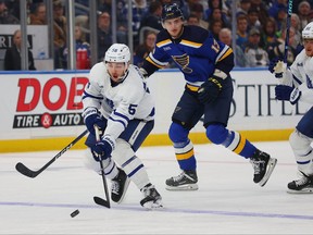 Michael Bunting of the Toronto Maple Leafs moves the puck up ice against Alexey Toropchenko of the St. Louis Blues in the second period at Enterprise Center on December 27, 2022 in St Louis, Missouri.
