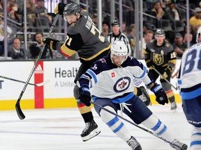 William Karlsson of the Vegas Golden Knights tries to get around Brenden Dillon of the Winnipeg Jets in the second period of their game at T-Mobile Arena on October 30, 2022 in Las Vegas, Nevada.