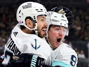 Oliver Bjorkstrand and Ryan Donato of the Seattle Kraken celebrate Donato's first-period goal against the Vegas Golden Knights during their game at T-Mobile Arena on November 25, 2022 in Las Vegas, Nevada.