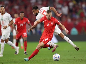 Alistair Johnston of Canada holds off Sofiane Boufal of Morocco during the FIFA World Cup Qatar 2022 Group F match at Al Thumama Stadium on December 01, 2022 in Doha, Qatar.