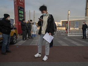 A man carries his release papers as he leaves after being released from a government quarantine facility on December 7, 2022 in Beijing.
