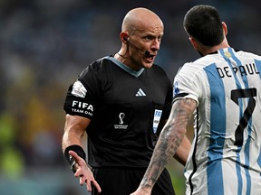 Argentina midfielder Rodrigo De Paul argues with Polish referee Szymon Marciniak.