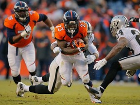 Running back Ronnie Hillman of the Denver Broncos rushes against the Oakland Raiders during a game at Sports Authority Field at Mile High on December 28, 2014 in Denver, Colorado.