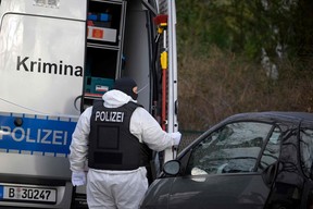 A policeman stands behind a car of the forensic experts during a raid on December 7, 2022 in Berlin that is part of nationwide early morning raids against members of a far-right “terror group” suspected of planning an attack.