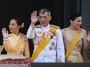 In this file photo taken on May 6, 2019, Thailand's King Maha Vajiralongkorn (C), Queen Suthida and his daughter Princess Bajrakitiyabha Mahidol (L) wave to well-wishers from the balcony of Suddhaisavarya Prasad Hall of the Grand Palace as they grant a public audience on the final day of his royal coronation in Bangkok.