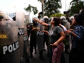 Supporters of former President Pedro Castillo clash with riot police during a protest to demand the closure of Congress and the release of Castillo in downtown Lima, on December 15, 2022.