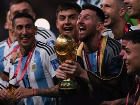 Argentina's captain and forward Lionel Messi lifts the FIFA World Cup Trophy during the trophy ceremony after Argentina won the Qatar 2022 World Cup final football match between Argentina and France at Lusail Stadium in Lusail, north of Doha on December 18, 2022.