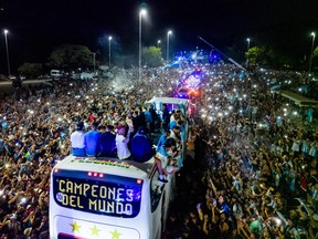 Argentina's players celebrate on board a bus with a sign reading "World Champions" with supporters after winning the Qatar 2022 World Cup tournament as they leave Ezeiza International Airport en route to the Argentine Football Association (AFA) training centre in Ezeiza, Buenos Aires province, Argentina on December 20, 2022.