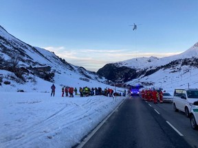 Rescue workers stand near the site where an avalanche in the Lech/Zuers free skiing area on Arlberg, Austria, December 25, 2022.