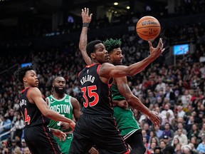 Raptors' Christian Koloko comes down with a rebound against Boston Celtics' Marcus Smart during the first half at Scotiabank Arena on Monday, Dec. 5, 2022.
