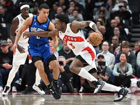 Raptors' OG Anunoby (right) dribbles the ball past Orlando Magic's Caleb Houstan during the first half at Scotiabank Arena on Saturday, Dec. 3, 2022.