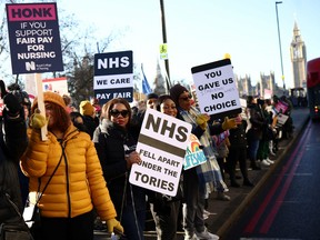 NHS nurses hold placards during a strike, amid a dispute with the government over pay, outside St Thomas' Hospital in London, Britain December 15, 2022.