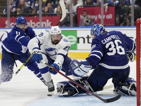 Tampa Bay Lightning left wing Nicholas Paul falls towards Toronto Maple Leafs goaltender Jack Campbell as Maple Leafs centre Colin Blackwell defends during third period NHL first-round playoff series action in Toronto on Saturday, May 14, 2022.