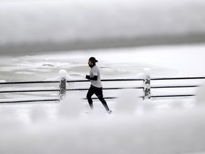 A runner makes their way along the Rideau Canal Pathway after a snowstorm in Ottawa, on Saturday, Dec. 17, 2022.