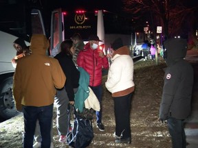 This image provided by WJLA shows migrant families as they get on to a bus to transport them from near Vice President Kamala Harris's residence to an area church after they arrived in Washington, Saturday, Dec. 24, 2022. (WJLA via AP)