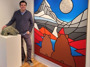 Indigenous artist and sculptor Jason Carter poses with one of his creations at the Carter-Ryan Gallery in Canmore, Alta.