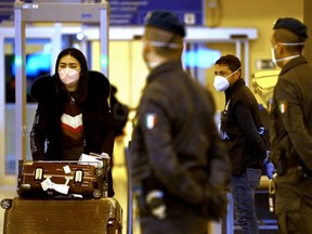 A Chinese traveller, left, leaves the arrival hall of Rome Fiumicino International Airport, near Rome, Italy, Thursday, Dec. 29, 2022 after being tested for COVID-19.