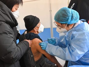 An elderly man receives a COVID-19 vaccine in Qingzhou, in China's eastern Shandong province, Friday, Dec. 16, 2022.