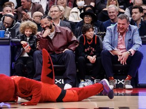 Drake and his son Adonis Graham watch as the Raptors mascot goofs around in front of them during a timeout in the first half of the NBA game between the Toronto Raptors and the Los Angeles Lakers at Scotiabank Arena on Dec. 7, 2022 in Toronto.