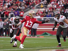 San Francisco 49ers quarterback Brock Purdy scores a touchdown in front of Tampa Bay Buccaneers linebackers Anthony Nelson (98) and  Devin White (45) in the second quarter at Levi's Stadium.
