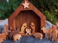 Figures and a manger scene in a rustic wood Christmas holiday nativity decoration.