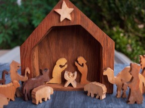 Figures and a manger scene in a rustic wood Christmas holiday nativity decoration.