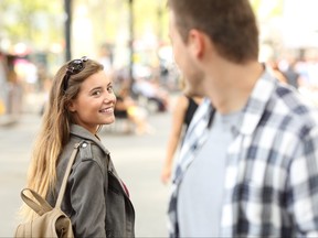 Strangers, a girl and guy, looking at each other on the street.