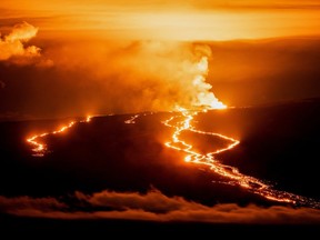 Lava fountains and flows illuminate the area during the Mauna Loa volcano eruption in Hawaii, Nov. 30, 2022.