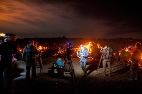 Members of the media report in front of a lava flow during the Mauna Loa volcano eruption in Hawaii, Nov. 30, 2022.