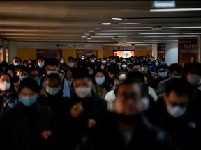 People wearing face masks walk in a subway station, as COVID-19 outbreaks continue in Shanghai, China, Dec. 8, 2022.
