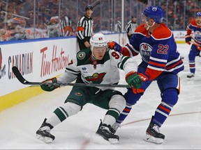 Minnesota Wild forward Kirill Kaprizov and Edmonton Oilers defensemen Tyson Barrie battle along the boards for a loose puck during the second period at Rogers Place.