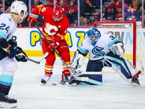 Seattle Kraken goaltender Joey Daccord makes a save against Calgary Flames center Jonathan Huberdeau during the third period at Scotiabank Saddledome.