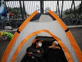 Activists lie inside a tent during a protest after Indonesia's parliament approved a new criminal code that will ban sex outside marriage, cohabitation between unmarried couples, insulting the president, and expressing views counter to the national ideology, outside the Parliament buildings in Jakarta, Indonesia, December 6, 2022.