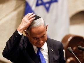 Israeli Prime Minister-designate Benjamin Netanyahu adjusts his kippah after speaking at a special session of the Knesset, Israel's parliament, to approve and swear in a new right-wing government, in Jerusalem December 29, 2022.