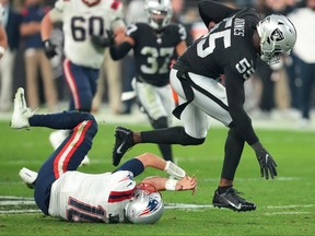 Las Vegas Raiders defensive end Chandler Jones (55) breaks the tackle of New England Patriots quarterback Mac Jones (10) after intercepting the ball and taking it for a game-winning touchdown at Allegiant Stadium on Sunday.