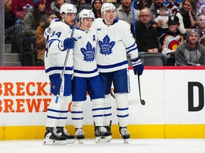 Toronto Maple Leafs right wing Mitch Marner (16) celebrates with centre Auston Matthews (34) and defenceman Justin Holl (3) after scoring a goal against the Colorado Avalanche.